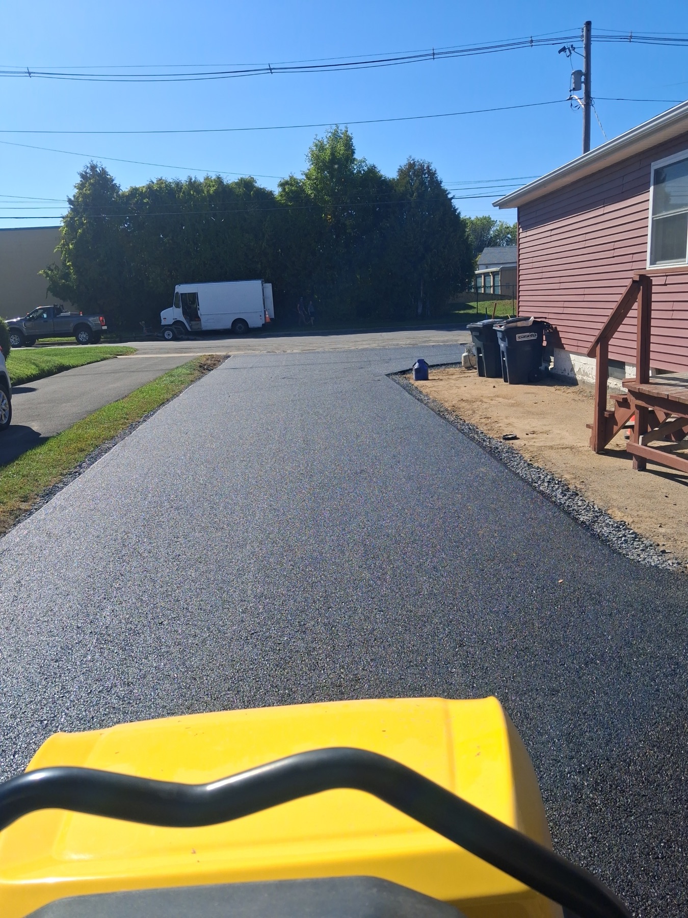 Fresh residential blacktop driveway being finished